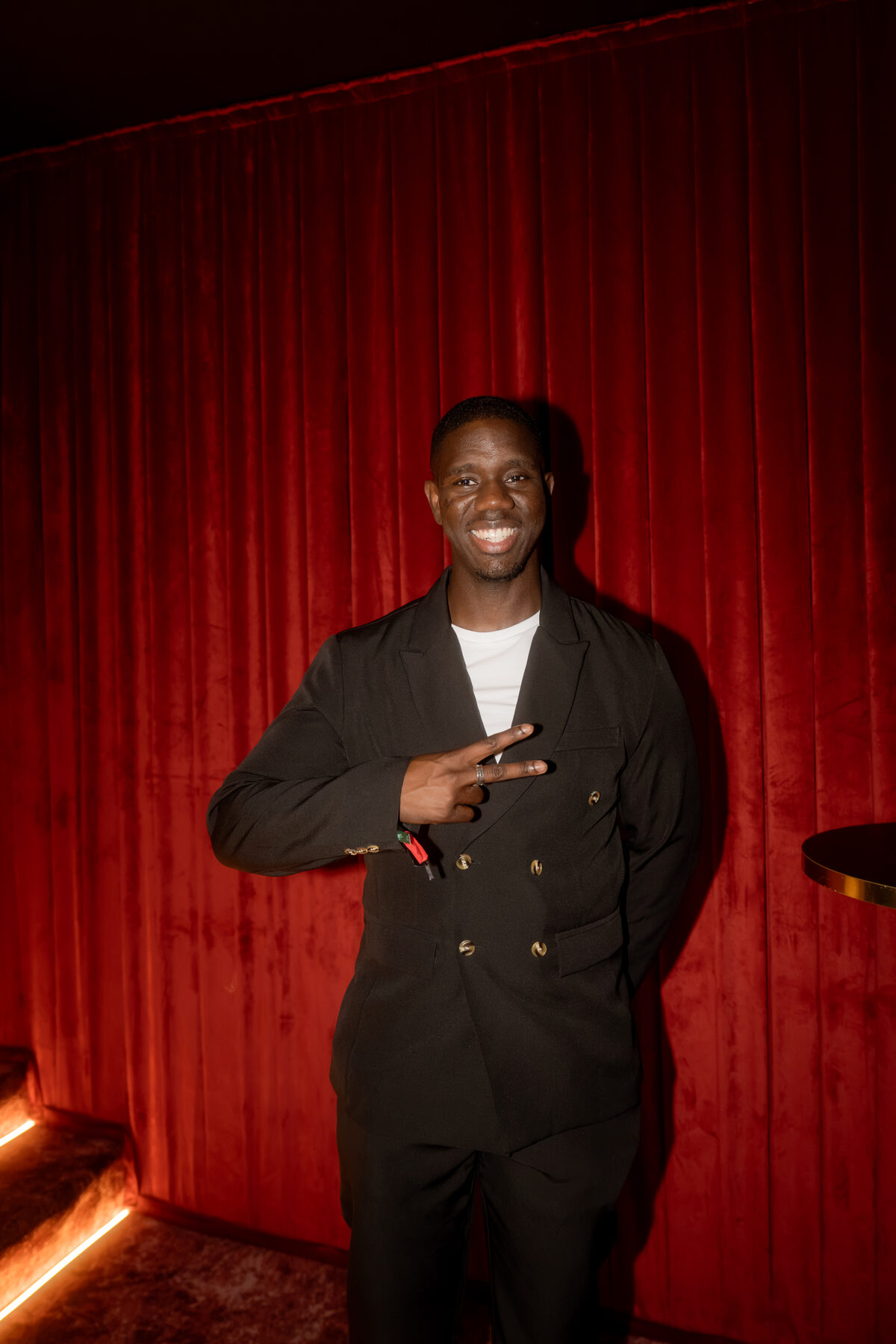 Guest in a tailored blazer against a deep red backdrop
