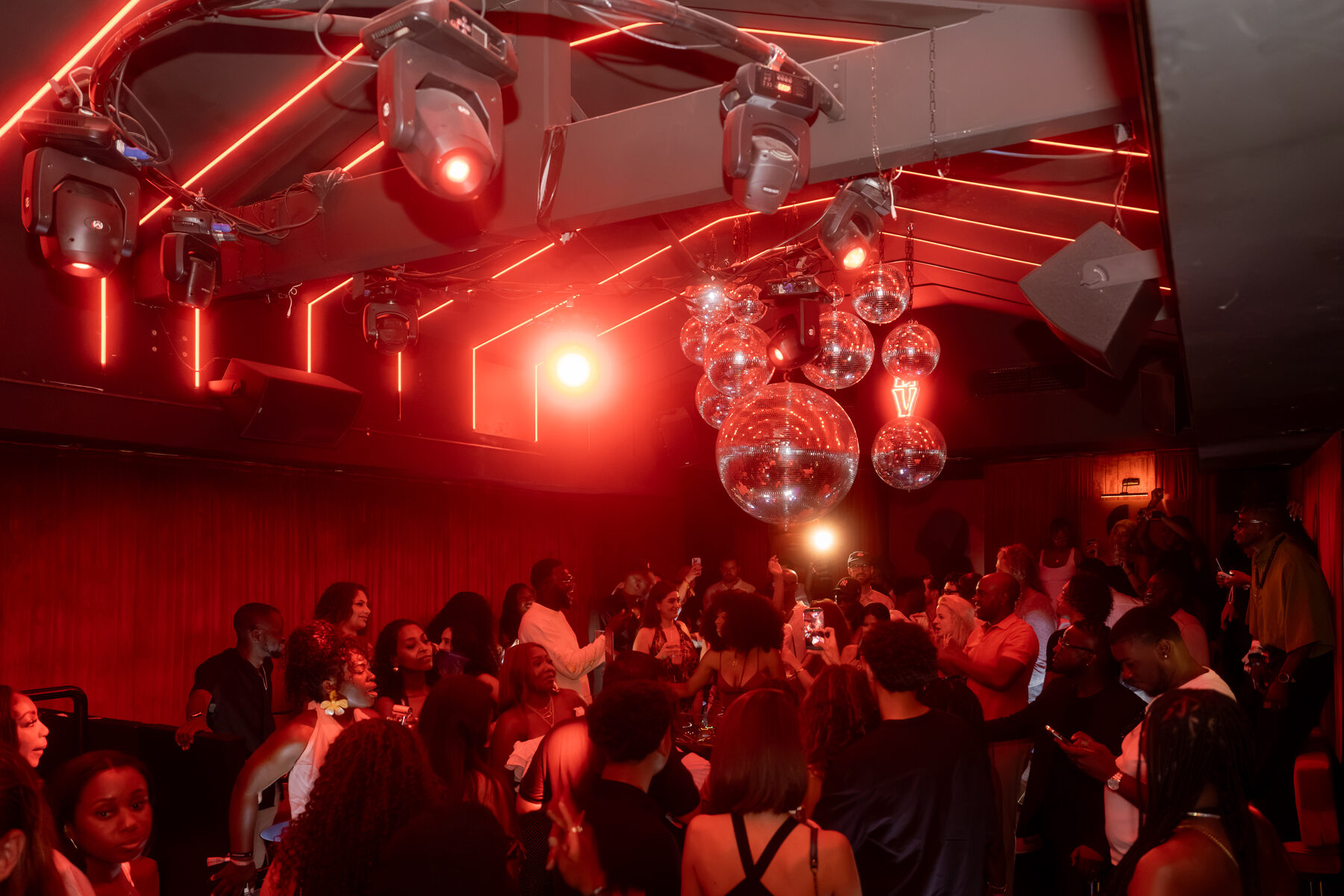 Full dancefloor under disco balls late at night