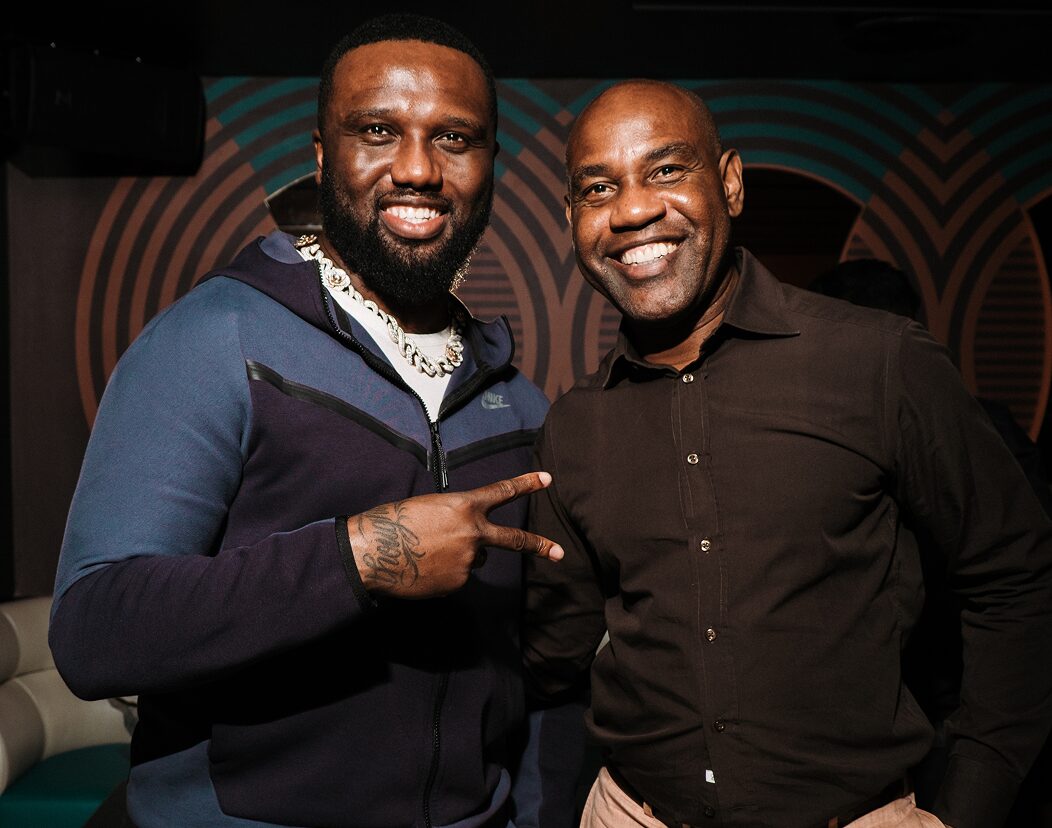 Two guests posing together in front of a retro-patterned backdrop