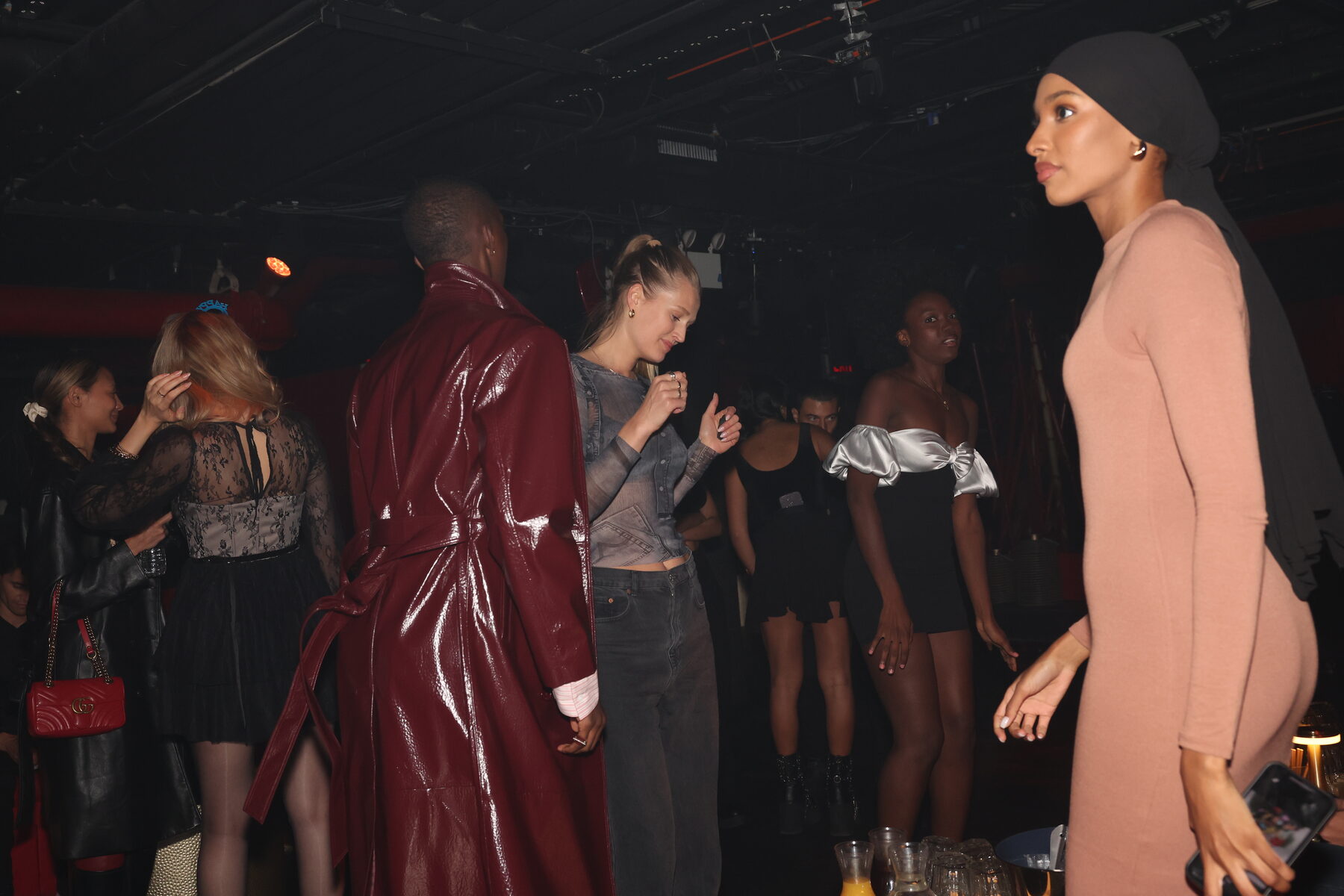 Models walking in a red-lit venue during Fashion Week